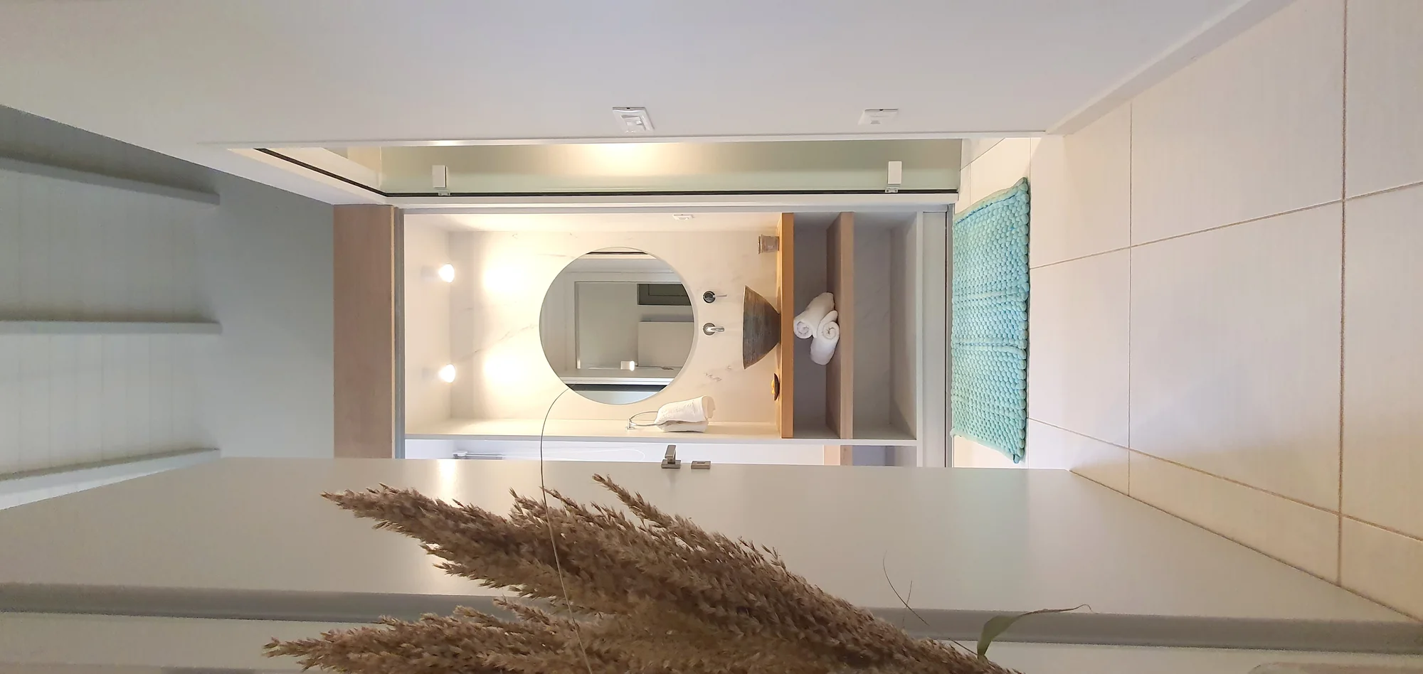 Modern bathroom with round mirror and stone vanity at Villa Erato, Physis Villas Chania