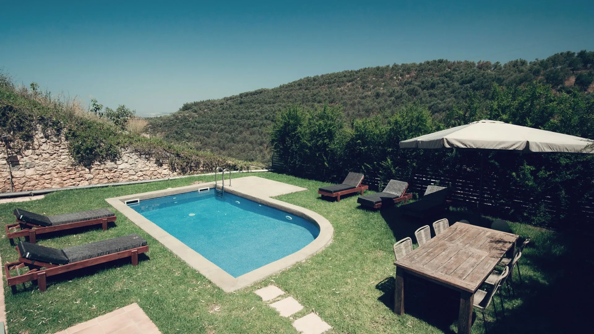 Villa Erato private swimming pool, sun loungers and shaded dining terrace with hillside view, Chania